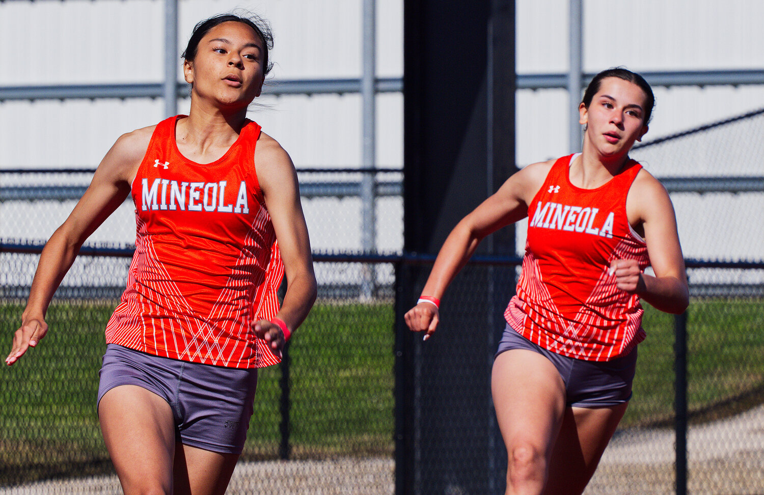 Mineola sprinters Stephanie Rojas and Carmen Carrasco round the bend in the 200m dash. [see more speed and strength on display]